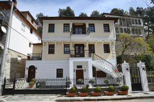 duży biały dom z czarnym płotem w obiekcie By The Lake w mieście Kastoria
