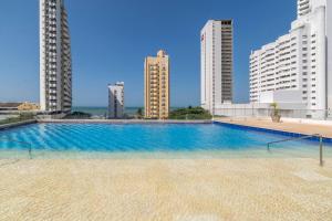 ein Schwimmbad in der Mitte von zwei hohen Gebäuden in der Unterkunft Montu 1404A Beautiful 2QueenBeds2bath w AC Near Beach in Cartagena de Indias
