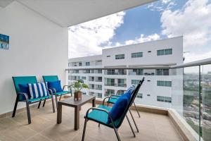 einen Balkon mit Stühlen, einem Tisch und einem Gebäude in der Unterkunft Montu 1404A Beautiful 2QueenBeds2bath w AC Near Beach in Cartagena de Indias