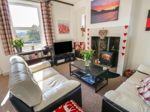 a living room with two couches and a fireplace at Canal View Cottage in Keighley