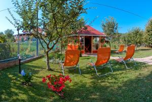 een groep stoelen in het gras in een tuin bij House Marinic in Grabovac