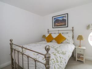 a bedroom with a metal bed with yellow pillows at 3 Lane End Court in Crewe
