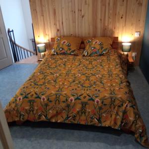 - un lit avec une couette en orange et 2 lampes dans l'établissement Chez BEN avec tout le confort clim wifi Netflix gratuit, à Castres