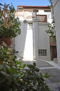 The Stonewall House - at the old town of Samos في Vathý: مبنى أبيض مع شرفة فوقه