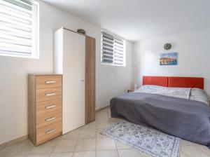 Schlafzimmer mit einem Bett, einer Kommode und einem Fenster in der Unterkunft Lola 2 in Rovinj