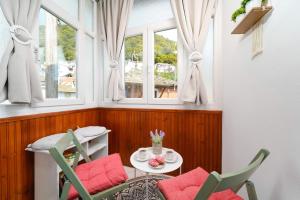 a room with a table and chairs and windows at La Casa de Fokas - Village Home in Panayia