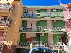 un bâtiment avec balcon et une voiture garée devant. dans l'établissement Casavacanze nel Blu scirocco, à Isola delle Femmine