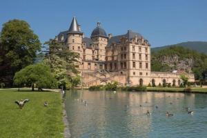 a large castle with ducks in the water in front of it at Saint Jacques Your Host Helper in Grenoble