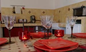 a kitchen table with red plates and wine glasses at A Furtezza in Soveria