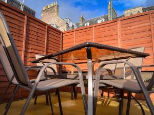 a table and chairs on a patio with a fence at The Nook Crieff - central 2-bed with garden :) in Crieff