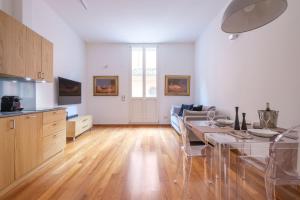 a kitchen and living room with a table and chairs at D'Azeglio & Galluzzi Suites in Bologna