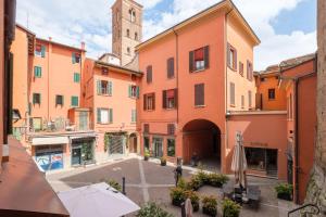 an alley in a city with a clock tower at D'Azeglio & Galluzzi Suites in Bologna