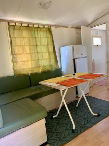 a kitchen with a table and a green couch at Tóparti Camping in Tiszafüred