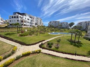 a park in the middle of a city with buildings at CABO NEGRO - LILAC'S GARDEN - PISCINE - JARDIN - PARKING in Martil