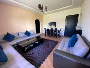 a living room with a couch and a table at CABO NEGRO - LILAC'S GARDEN - PISCINE - JARDIN - PARKING in Martil