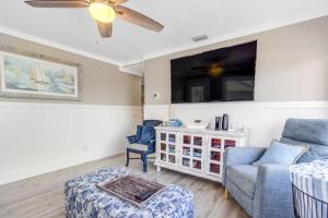 uma sala de estar com um sofá e uma televisão em Seagrass Sunsets em Bradenton Beach