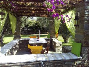 a patio with a table and chairs under a pergola at Pension Sofia in Parikia