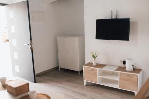 sala de estar con TV en una pared blanca en Apartamento "Aires de Jerez" - Centro, en Jerez de la Frontera