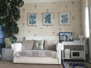 a living room with a white couch in a room at Arun Sands Rooms in Littlehampton