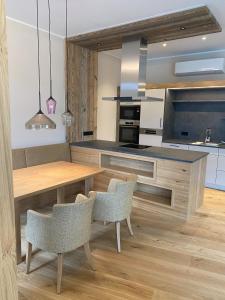 eine Küche mit einem Holztisch und Stühlen in der Unterkunft Gasthof Schorn in Sankt Leonhard