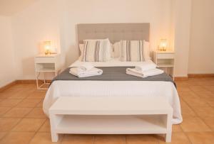 a bedroom with a white bed with two towels on it at Apartamentos Casa Tuli C, ALJARAQUE in Aljaraque