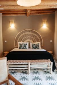 a bedroom with a bed with a wooden ceiling at Domaine de Tameslohte in Tameslouht