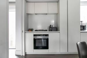 a kitchen with white cabinets and a stove at New Build-Air Con-2 Bedroom-Two Bathrooms Apt 6 in London