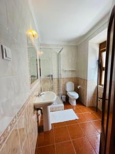 a bathroom with a sink and a toilet at Só Mar in Vila Nova de Milfontes