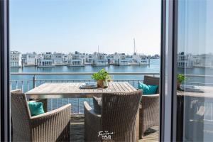 a table and chairs on a balcony with a view of the water at Traumblick in Olpenitz