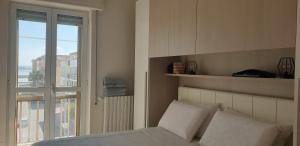 Schlafzimmer mit einem Bett und einem Fenster mit Aussicht in der Unterkunft Appart terrasse vue mer Tito in Margherita di Savoia