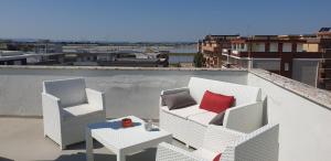2 weiße Stühle und ein Tisch auf dem Dach in der Unterkunft Appart terrasse vue mer Tito in Margherita di Savoia