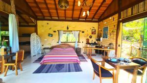 a bedroom with a bed and a table and chairs at Ecopousada Toca do Guará in Alto Paraíso de Goiás