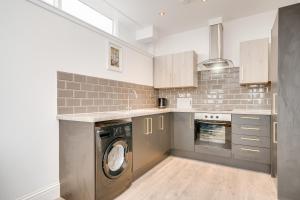 a kitchen with a washer and dryer in it at Town House Apartments in Wakefield