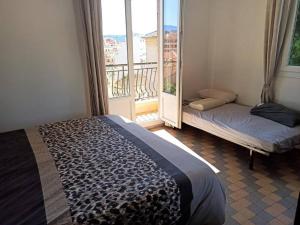 a bedroom with a bed and a window with a balcony at Villa tres proche du centre ville in Nice