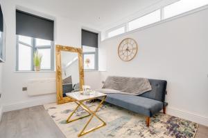 a living room with a blue couch and a mirror at Town House Apartments in Wakefield