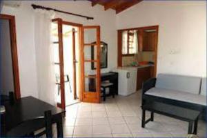 a living room with a bed and a table and a kitchen at Δίχωρο στούντιο στον κέντρο του Αρμενιστή in Armenistis