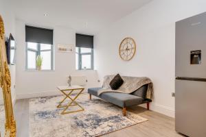a living room with a chair and a clock on the wall at Town House Apartments in Wakefield