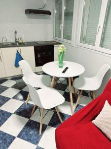 uma cozinha com uma mesa e cadeiras com um vaso de flores em Porte la chapelle appartement 4 personnes "Appart'5" em Pierrefitte-sur-Seine