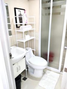 een badkamer met een toilet en een wastafel bij Lancris Residences 2 Bedroom Entire Apartment near Airport with Pool in Manilla