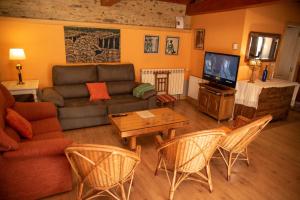 a living room with a couch and a tv at Casa Fonte do Barro SPA opcional in Santiago de Compostela