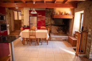 a kitchen and dining room with a table and chairs at Casa Fonte do Barro SPA opcional in Santiago de Compostela