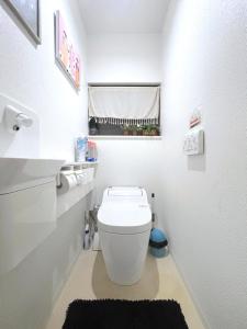 bagno con servizi igienici bianchi e tappeto nero. di guesthouse中道 ad Osaka