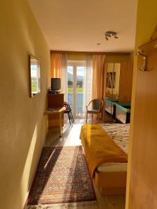 a bedroom with a bed and a living room at Pension Carinthia in Unterburg am Klopeiner See
