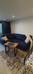 a living room with a blue couch and a coffee table at Apartament Kopernik in Bystrzyca Kłodzka
