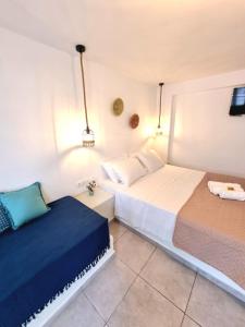 a bedroom with two beds and a tv on the wall at Joannes Vacation Rooms in Adamantas