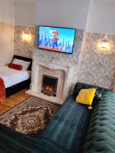 Liverpool Lux stay في ليفربول: غرفة معيشة مع موقد وتلفزيون على الحائط
