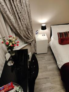Liverpool Lux stay في ليفربول: غرفة نوم بسرير وطاولة مع ورد