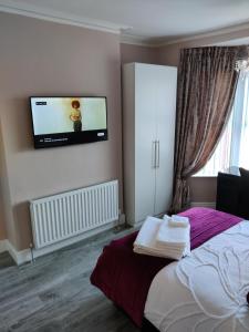 a bedroom with a bed with a flat screen tv on the wall at Liverpool Lux stay in Liverpool
