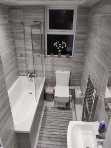 a bathroom with a tub and a toilet and a sink at Liverpool Lux stay in Liverpool