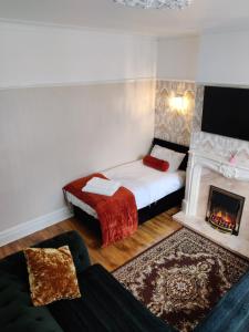 Liverpool Lux stay في ليفربول: غرفة نوم صغيرة مع سرير ومدفأة